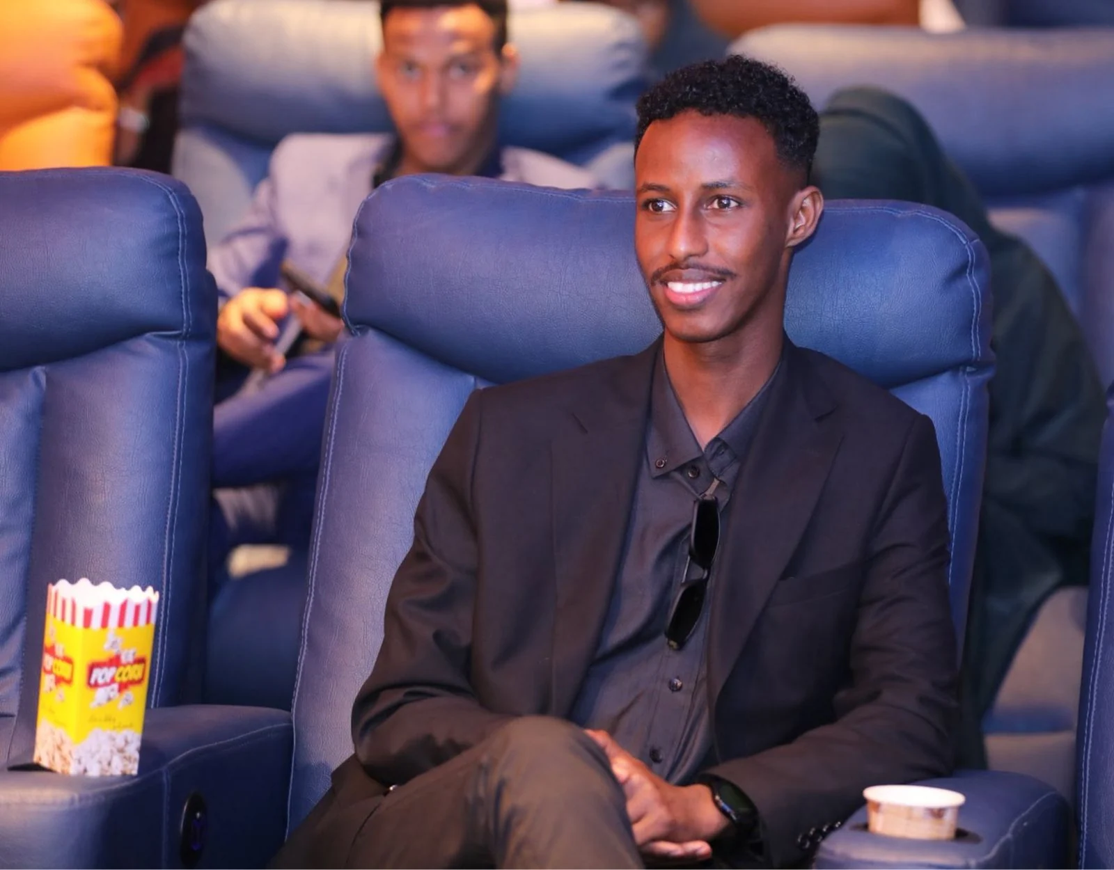 An attendee seated in a cinema audience