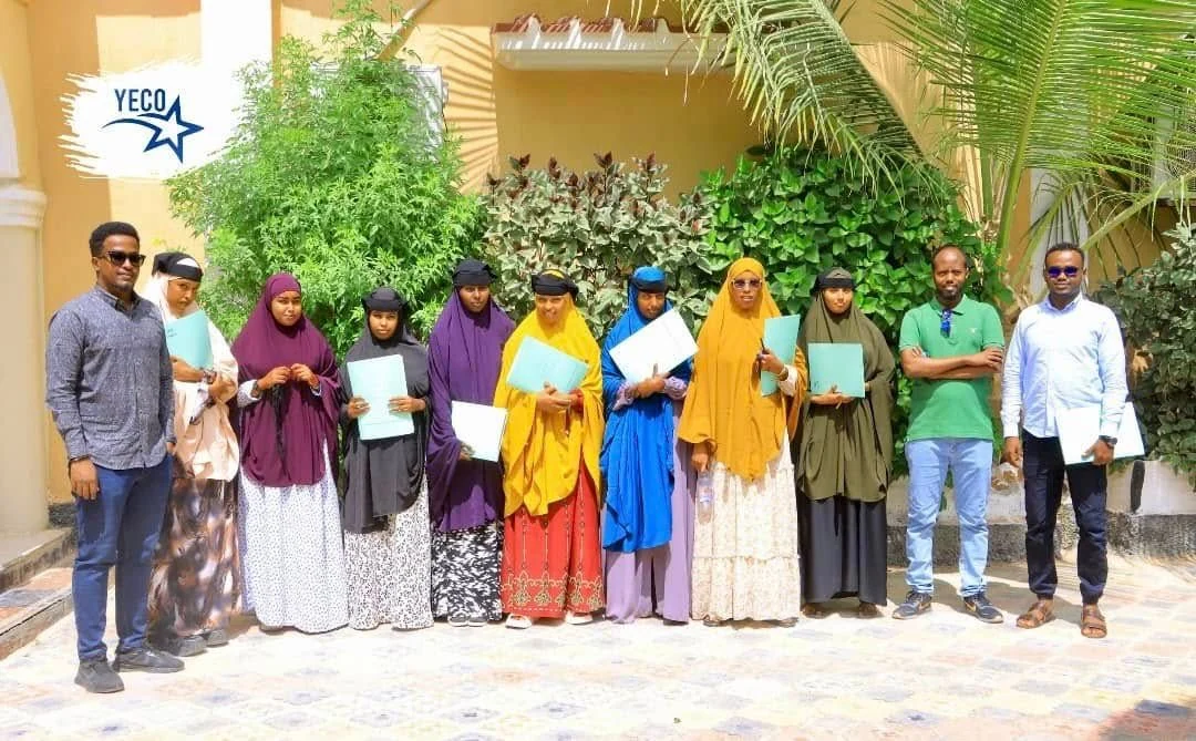 Women and other participants holding documents outside a YECO venue